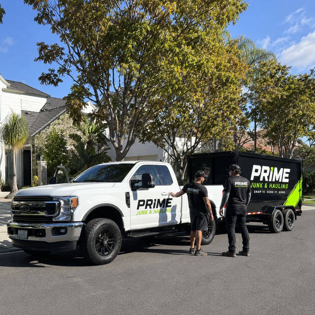 Prime Junk & Hauling crew and branded truck with dump trailer on a residential street in Orange County